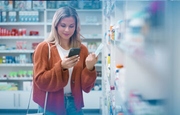 Frau beim Einkaufen im Geschäft am Smartphone